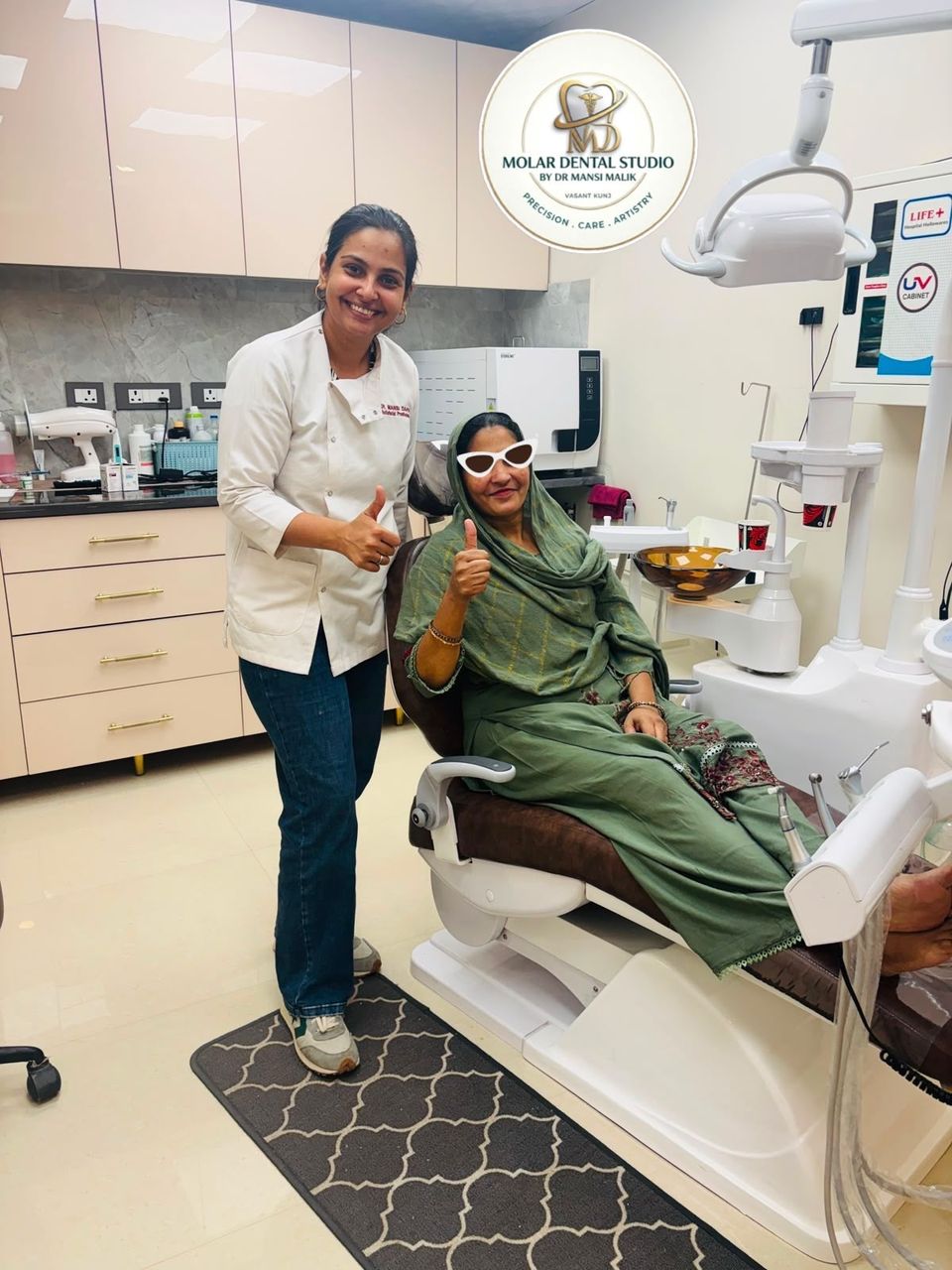 Dr. Mansi Dahiya Malik beside a patient seated in the dental chair at the studio