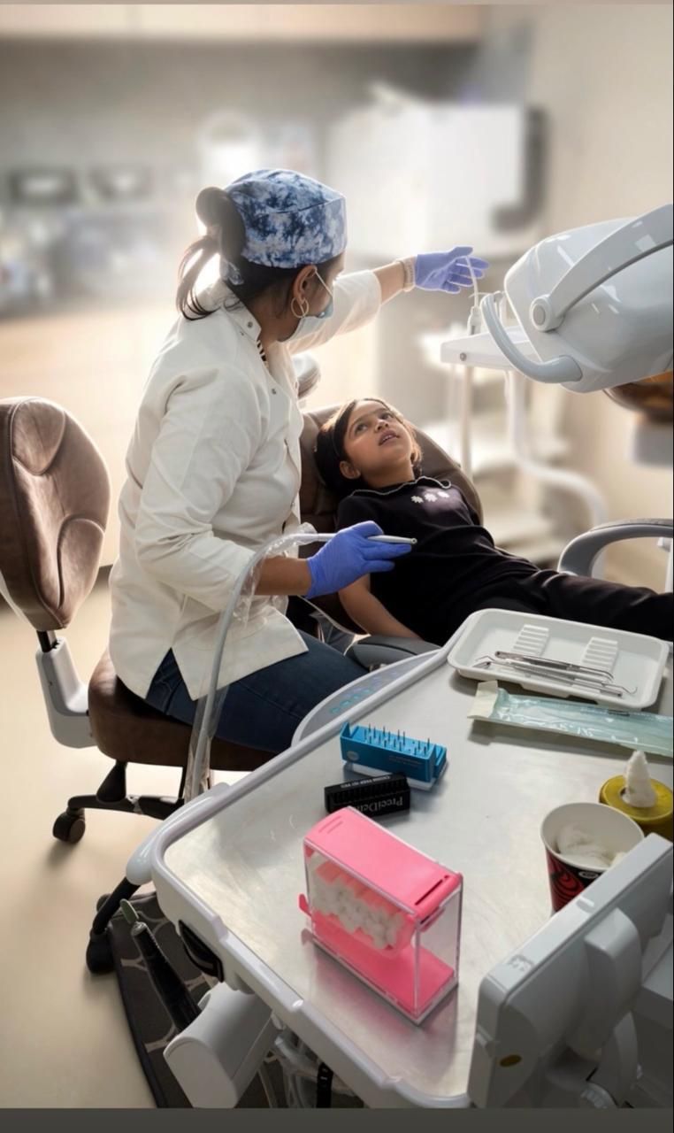 A patient being treated in the dental chair under the operating light