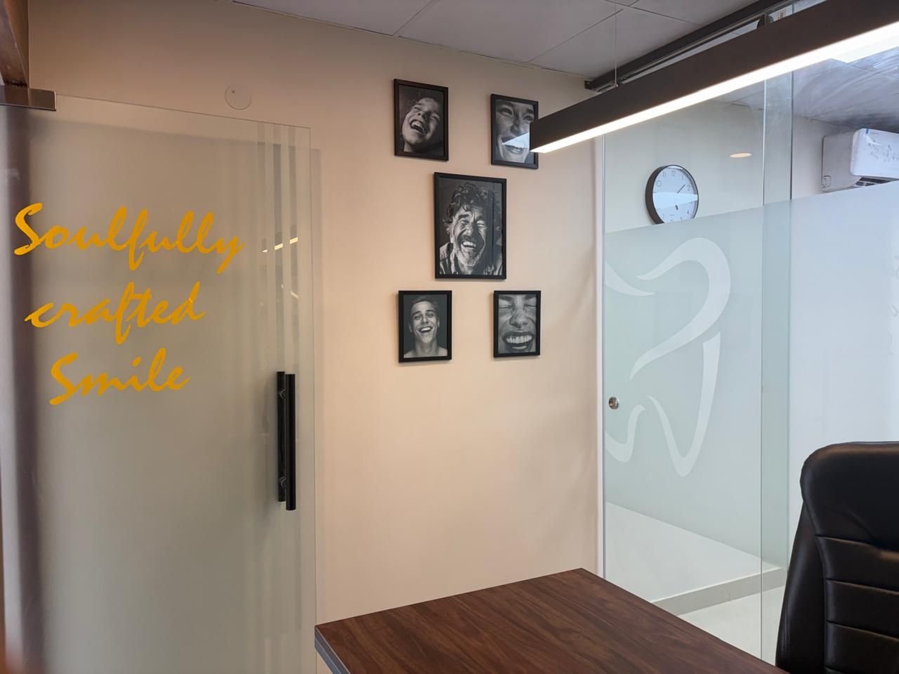 The clinic wall with framed photographs and the words Soulfully crafted Smile in gold
